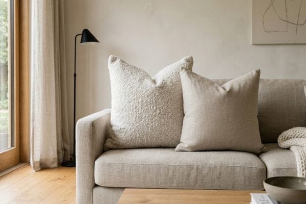 Properly styled couch pillows using oversized feather inserts and mixed textures for a high-end look.