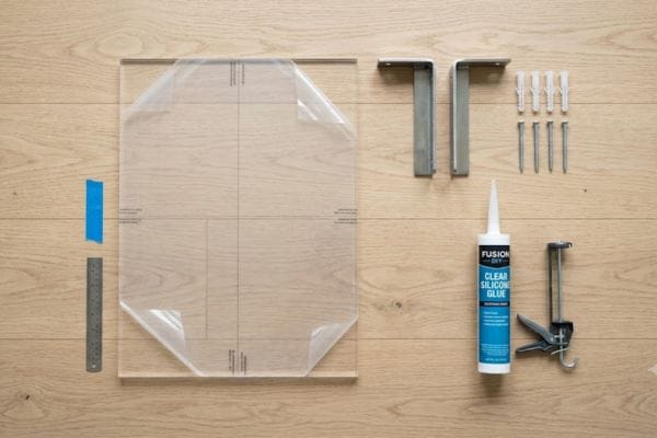 Clear plexiglass sheets with brackets and silicone glue on a wooden background