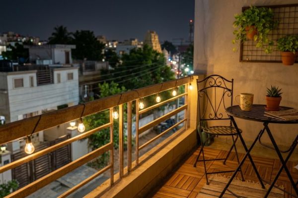 Warm fairy string lights wrapped around a balcony railing at night.